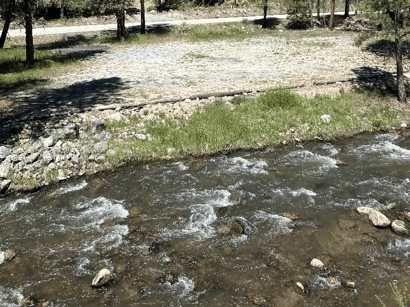 Mores Creek running white over rocks along the edge of the property.